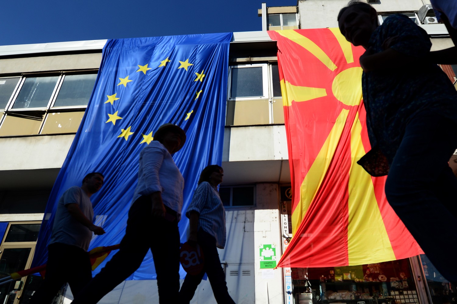 Грађани Скопља пролазе поред великих застава ЕУ и Северне Македоније током марша за европску Македонију, 16. септембар 2018. (Фото: EPA-EFE/Nake Batev)