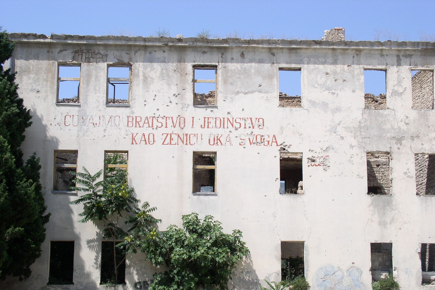 Zgrada bivše kasarne JNA u Mostaru sa natisom – „Čuvajmo bratstvo i jedinstvo, kao zjenicu oka svog“ (Foto: Wikimedia/Antidiskriminator, CC BY-SA 3.0)
