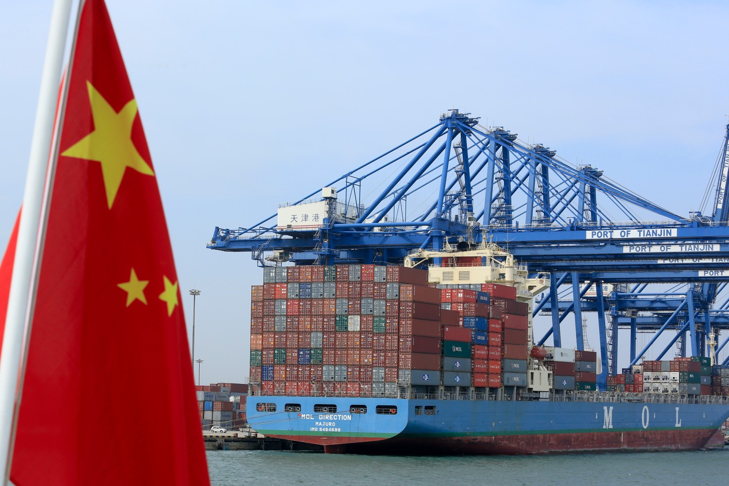 Kineska zastava nedaleko od brodskih kontejnera u luci u Tjanđinu (Kina) (Foto: Nelson Ching/Bloomberg)