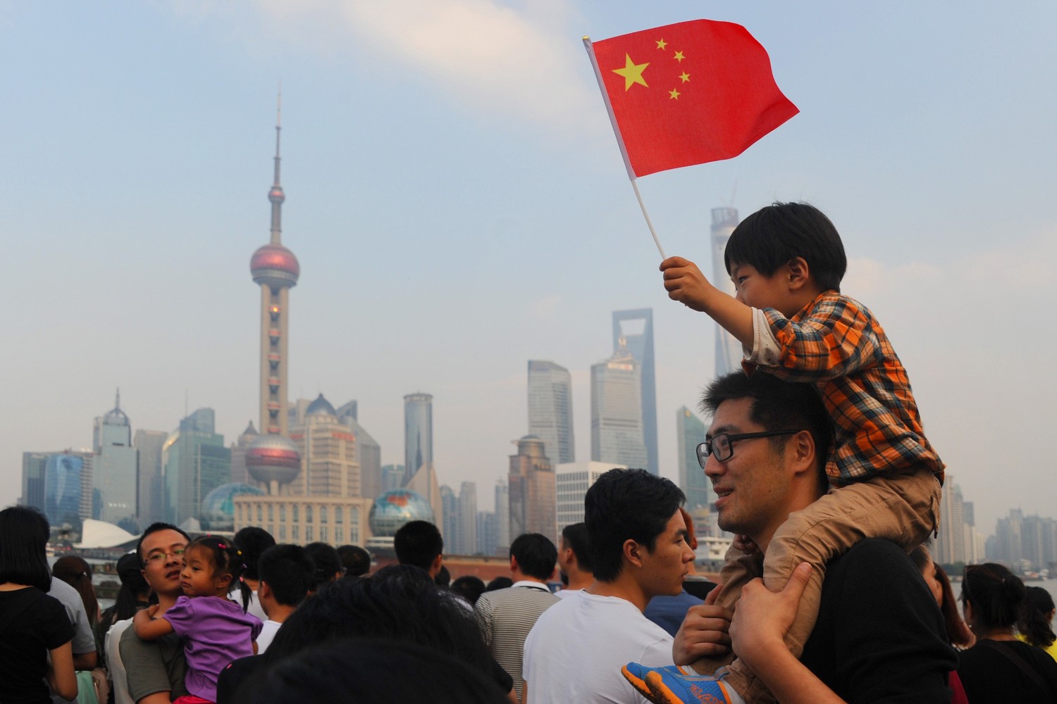 Дечак на леђима свог оца са кинеском заставом током другог дана Националног празника Кине, Шангај, 02. октобар 2014. (Фото: VCG/VCG via Getty Images)