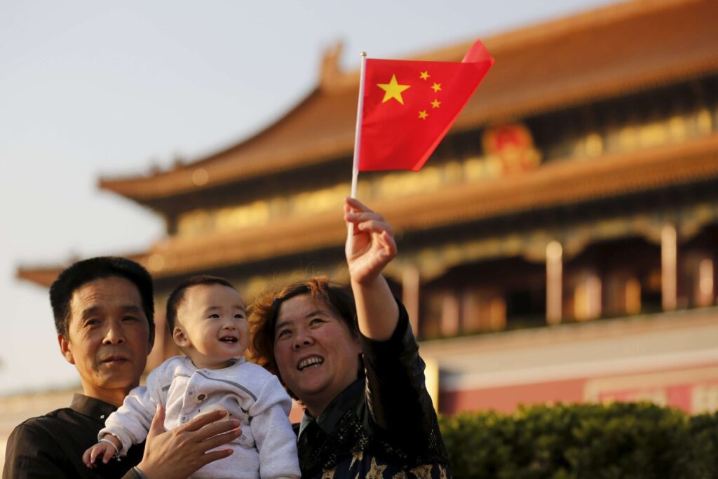 Kineska porodica sa zastavicom Kine u Pekingu (Foto: Reuters/Kim Kyung Hoon)