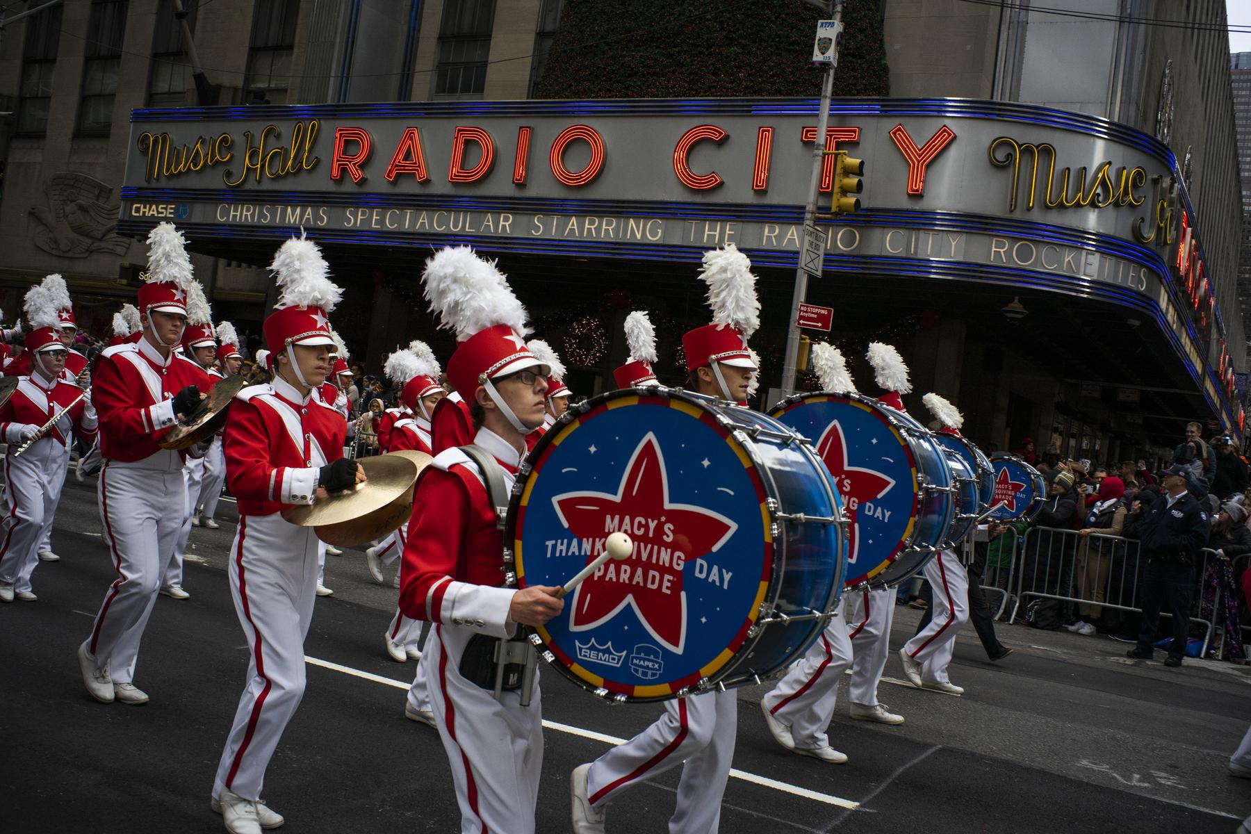 FILE - Revelers makes their way down the Avenue of the Americas in front of Radio City Music Hall during the Macy's Thanksgiving Day Parade in New York on Nov. 28, 2019. This year’s parade will snap back to form after bowing to pandemic restrictions last year. It will feature 15 giant character balloons, 28 floats, 36 novelty and heritage inflatables, more than 800 clowns, 10 marching bands and nine performance groups and, of course, Santa Claus (AP Photo/Eduardo Munoz Alvarez, File)