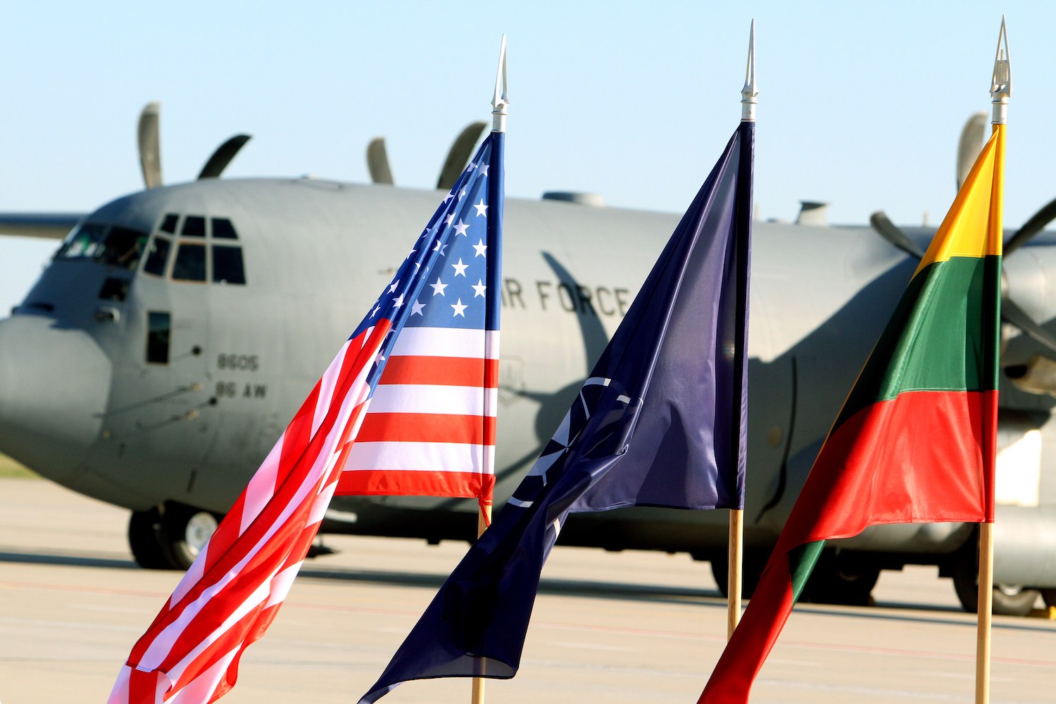 Flags of the US, NATO are hoisted in front of an aircraft of the US air force carrying US soldiers at the air force base near Siauliai Zuokniai, Lithuania, on April 26, 2014. US troops arrived in Lithuania, part of a US contingent of 600 sent to the region to reassure NATO allies amid the escalating Ukraine crisis. AFP PHOTO / PETRAS MALUKAS (Photo credit should read PETRAS MALUKAS/AFP via Getty Images)