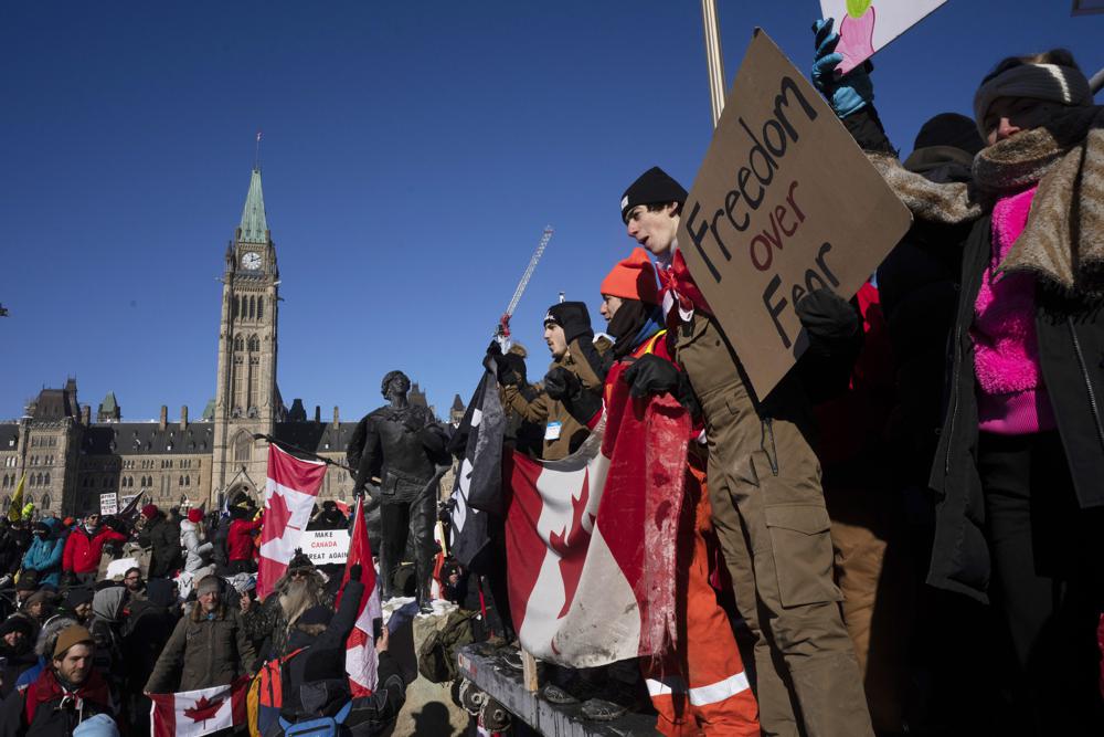 Protesters participating in a cross-country truck convoy protesting measures taken by authorities to curb the spread of COVID-19 and vaccine mandates gather near Parliament Hill in Ottawa on Saturday, Jan. 29, 2022. Thousands of antivaccine protesters descended on Canada’s capital of Ottawa in frigid temperatures to protest vaccine mandates, masks and restrictions over the weekend and some remain, blocking traffic around Parliament Hill in what has been the biggest pandemic protest in the country to date.(Adrian Wyld/The Canadian Press via AP)