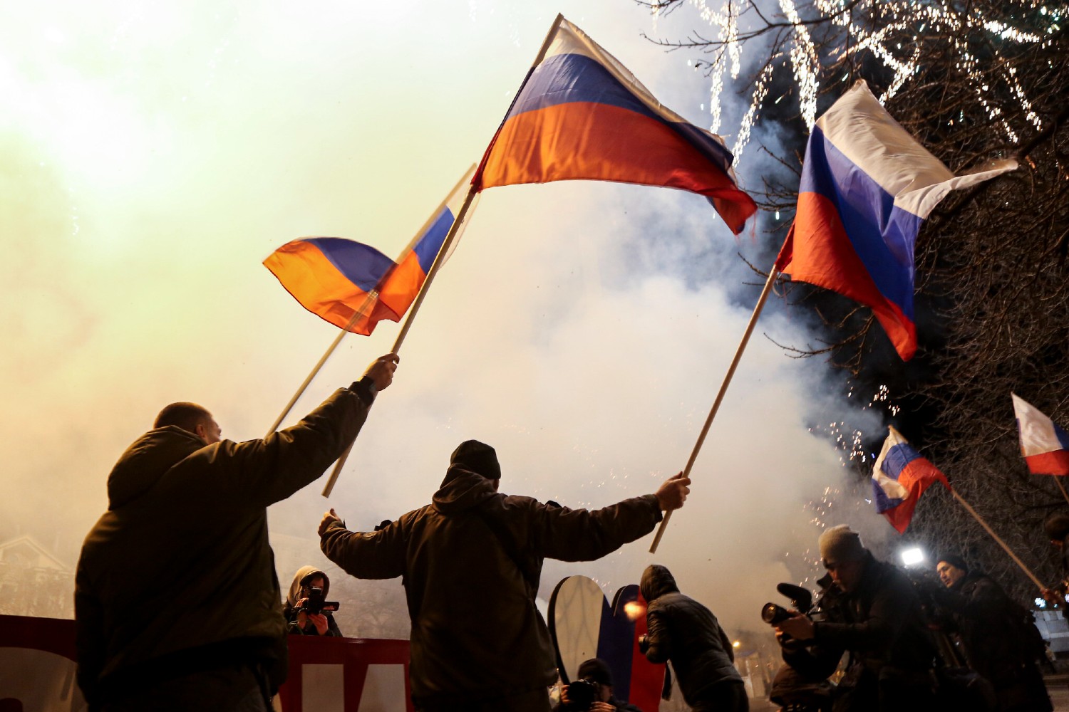People wave Russian national flags to celebrate, in the center of Donetsk, the territory controlled by pro-Russian militants, eastern Ukraine, late Monday, Feb. 21, 2022. (AP/Alexei Alexandrov)